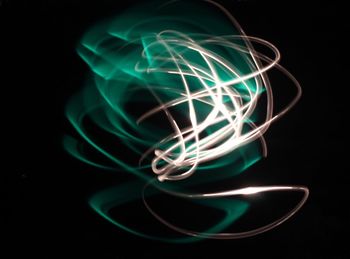 Close-up of illuminated light bulb against black background