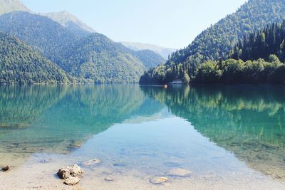 Scenic view of lake and mountains against clear sky