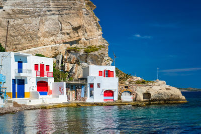 Buildings by sea against sky