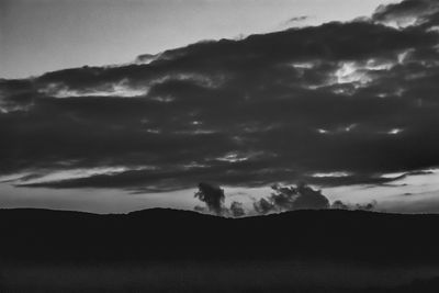 Scenic view of dramatic sky over silhouette mountain