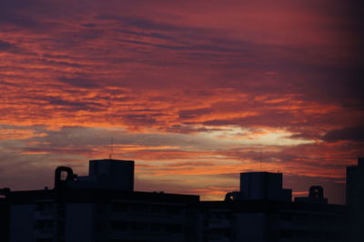 Silhouette cityscape against sky during sunset