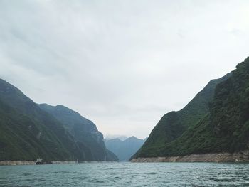 Scenic view of sea and mountains against sky