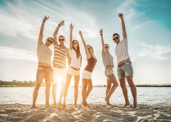 Happiness friends fun on beach under sunset sunlight in summer sunny day. funny group games.