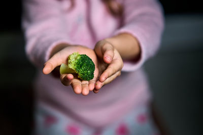 Selective focus of the hands from a girl with broccoli for a healthy meal