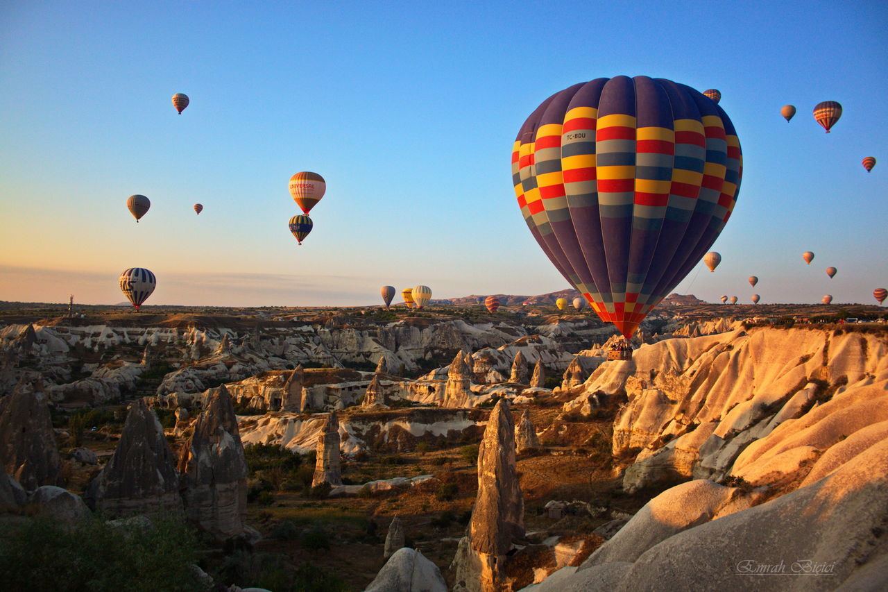 VIEW OF HOT AIR BALLOONS FLYING OVER ROCK