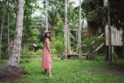 Woman standing by trees in forest