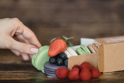 Cropped image of hand holding strawberries in box