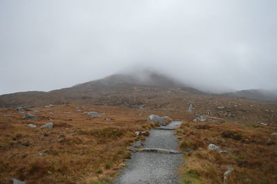 Scenic view of landscape against sky during foggy weather