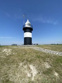 Lighthouse by sea against sky