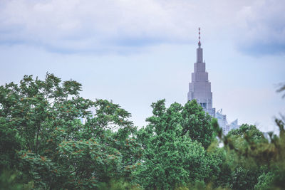 Low angle view of trees and building against sky