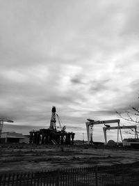 Low angle view of construction site against cloudy sky