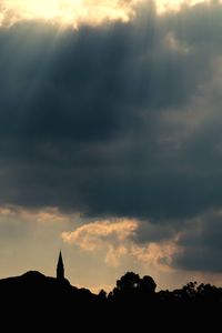 Silhouette of trees against cloudy sky