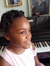 Portrait of cute girl playing piano at home