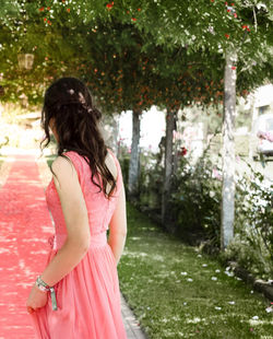 Rear view of woman standing against pink trees