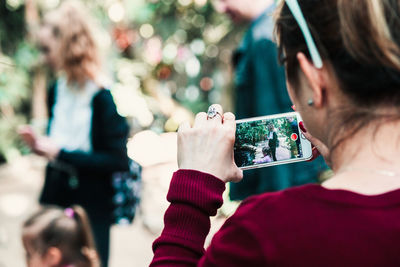 Rear view of people photographing outdoors