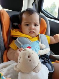 Portrait of cute baby girl in car