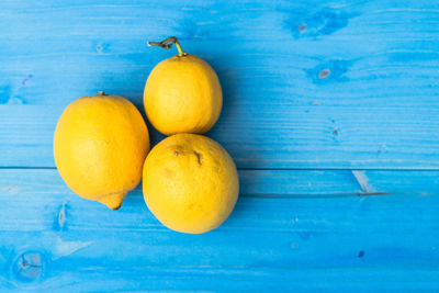 Directly above view of fresh lemon - fruits on blue wooden table