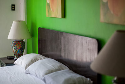 Close-up of electric lamp on bed at home