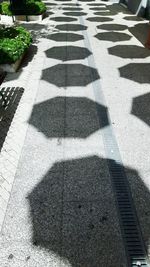 High angle view of shadow on footpath in city