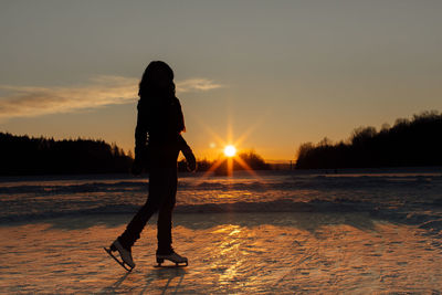 Smiling woman ice-skating on frozen lake