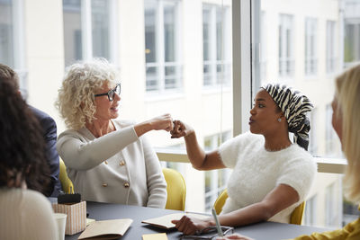 Businesswomen fist bumping in office