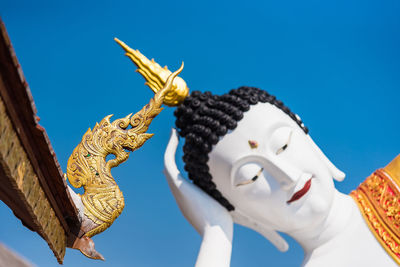 Low angle view of statue against temple against clear sky