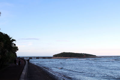 Scenic view of beach against clear sky at sunset