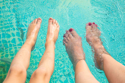Low section of woman feet in swimming pool