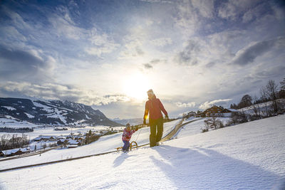 People on snow against sky