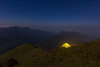 Scenic view of illuminated mountains against sky at night