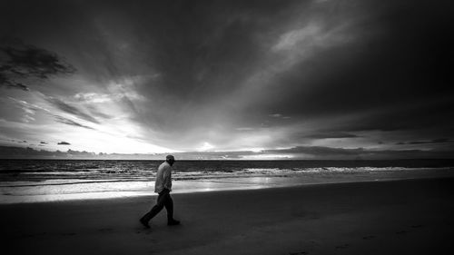 Man standing on beach against sky