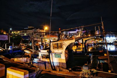 Illuminated boats moored at harbor