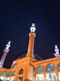 Low angle view of illuminated building against sky at night