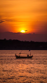 Silhouette boat in sea against sky during sunset