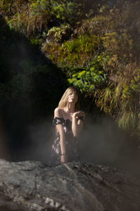 Woman standing on rock in forest