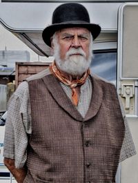 Portrait of mature man wearing hat while standing by car