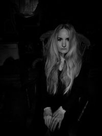 Portrait of woman sitting in the dark