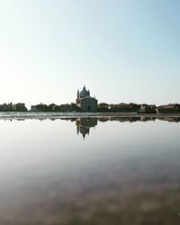 Reflection of building in lake against sky