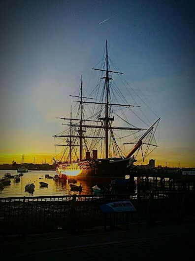 sunset, nautical vessel, transportation, mode of transport, moored, boat, sky, silhouette, water, sea, mast, clear sky, harbor, sun, orange color, sunlight, travel, dusk, outdoors, nature