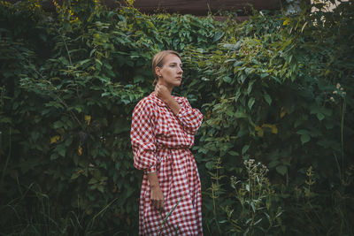 Full length of woman standing against plants