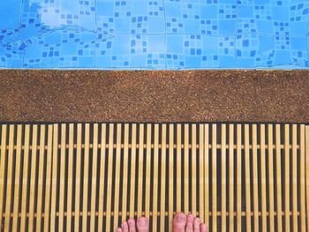 Low section of person standing at poolside