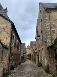 Narrow alley amidst old buildings against sky