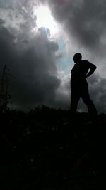 Silhouette of woman against cloudy sky