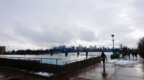 Panoramic view of people on shore against sky