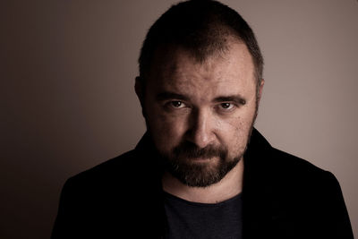 Close-up portrait of man against gray background