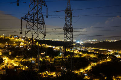 Low angle view of electricity pylon at night