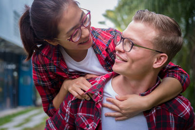 Smiling man carrying girlfriend on shoulder