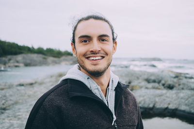 Portrait of young man smiling at beach
