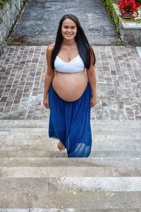 Portrait of young woman standing against wall