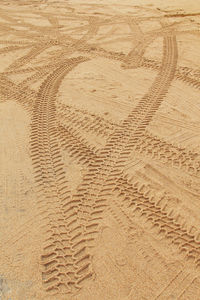 Full frame shot of tire tracks on sand